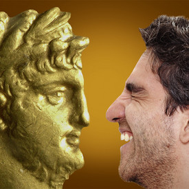 Junger Mann schaut auf den Kopf einer römischen Figur